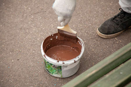 Paint bucket. Painting work in the summer. The painter prepared his tool. Oil paint in a jar. Work on the improvement of the park.の写真素材