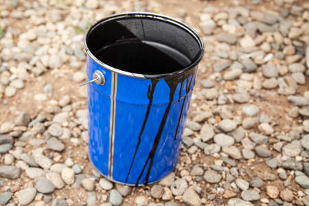 Paint bucket. Painting work in the summer. The painter prepared his tool. Oil paint in a jar. Work on the improvement of the park.の写真素材