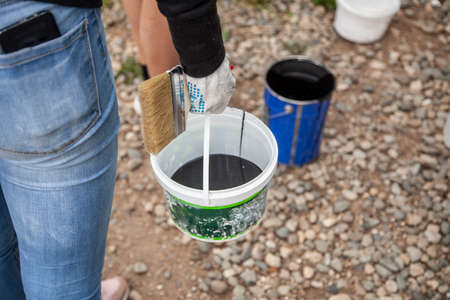 Paint bucket. Painting work in the summer. The painter prepared his tool. Oil paint in a jar. Work on the improvement of the park.の写真素材