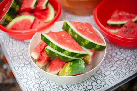 Watermelon on the table. Juicy red waterbaz cut into wedges. Delicious summer food. Healthy diet. Sweet berry. Afternoon snack on the street.の写真素材