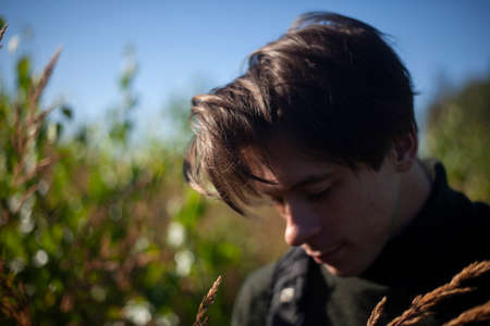 Portrait of a guy at dawn. A young man in the woods. Pensive mood. Clarity of mind in a man. Outdoor recreation. Walk with a model in the Park.の写真素材