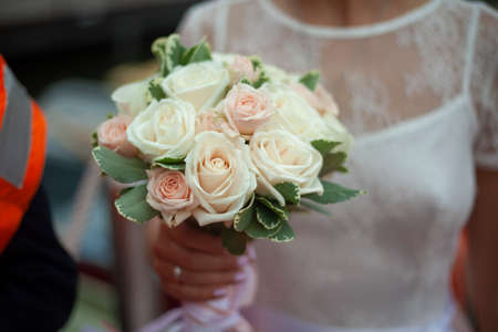 Bride's bouquet. The girl is holding a bouquet of white roses. The bride in a white dress with flowers.の写真素材