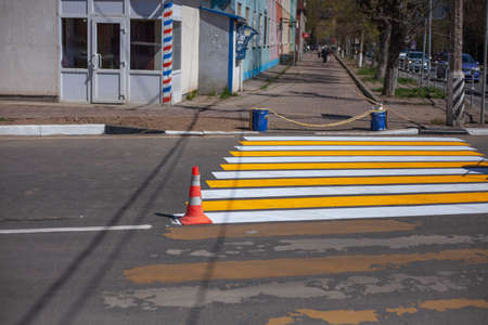 Painting the pedestrian zone. Pedestrian crossing over the highway. The markings on the road. Warning strips.の写真素材