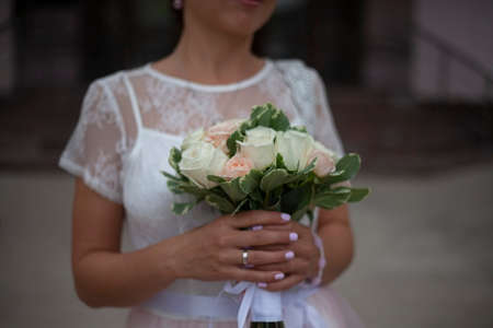 Bride's bouquet. The girl is holding a bouquet of white roses. The bride in a white dress with flowers.の写真素材
