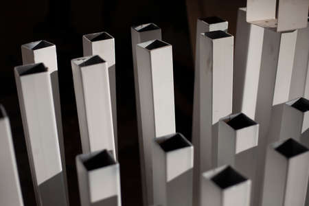 Square metal profile. Metal profile painted in white color. Steel parts of the structure. Material in the workshop.の写真素材