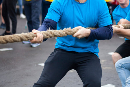 Men's tug of war competition. Guys show male power. Large rope for mooring boats. Weightlifting...