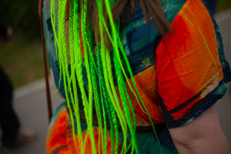 Synthetic hair. Pigtails woven into the girl's hair. Green dreadlocks. The culture of weaving dreadlocks. Fancy Hairstyle.の写真素材
