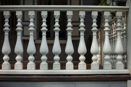 Balusters in the decoration of the veranda railings. An architectural element made of wood. An old manor outside the city. Detail of a building from the last century.の写真素材