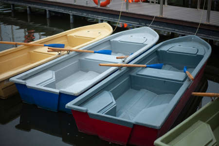 Boats on the water. Boat station on the pond. Swimming aids. Water transport moored to the pier.の写真素材