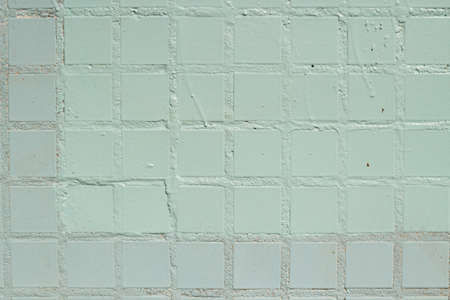 Checkered texture. Tiled wall. A blue surface divided into even squares. Painted wall background.の写真素材