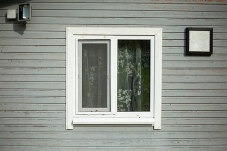 Window with a white frame. A wall of planks with a square window. Vacation home.