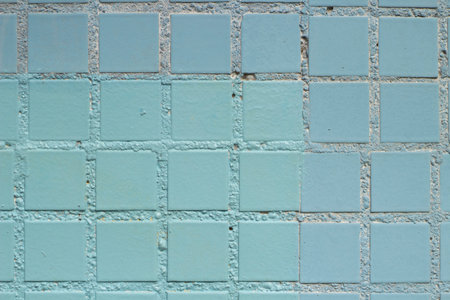 Checkered texture. Tiled wall. A blue surface divided into even squares. Painted wall background.
