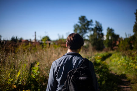 The guy travels to untouched places of nature. A man walks across the field. Young man shot from the...