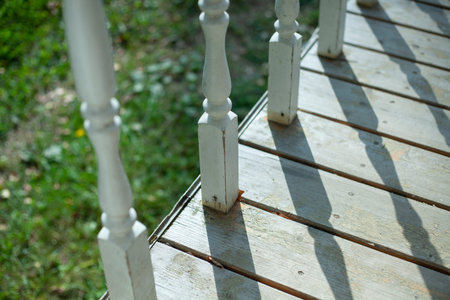 Balusters on the veranda. The railings are white. Decorative element. Wooden details of the...