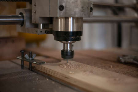 CNC drilling machine. Drill work on wood. Making holes in the board. The work of an electric milling machine.の写真素材