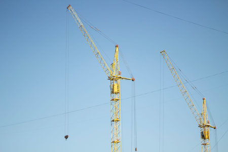 Tower crane at a construction site. Large crane with ropes for lifting loads. Construction work on...