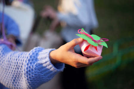 Paper strawberries. The child shows his hobby. DIY paper toy. Girl holding origami in hand. Demonstration of the result of your creativity.の写真素材