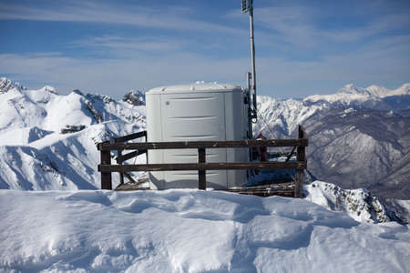 Communication equipment in the mountains. The repeater is located at a high altitude. Special technology in cold conditions. Communication tower. Communication means out of reach.の写真素材