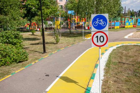 Bicycle path for children in the park. Cycling infrastructure. Asphalt path in the city. Place for a walk. Painted yellow asphalt. A place for cycling.の写真素材