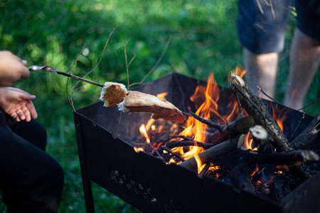 Fried bread at the stake. Making crispy white bread. Delicious food outside.の写真素材