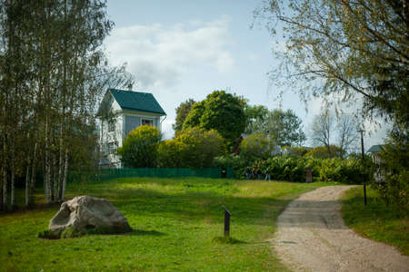 Rural landscape. View of the lawn. Plot of land around the old manor. The place where the poet Alexander Blok lived. A large stone in the middle of the grass. Landscaping of the territory.の写真素材