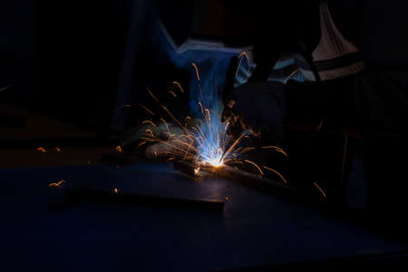 Sparks from metal welding. Welder to work. High temperature when working with a welding machine. Create a metal structure using a metal joint.の写真素材