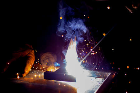 Sparks from metal welding. Welder to work. High temperature when working with a welding machine. Create a metal structure using a metal joint.の写真素材