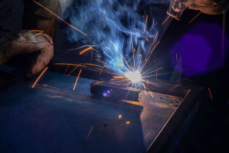 Sparks from metal welding. Welder to work. High temperature when working with a welding machine. Create a metal structure using a metal joint.の写真素材