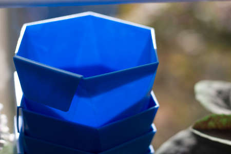 Blue plant pot. Plastic container in sunlight. The thing is on the balcony.の写真素材