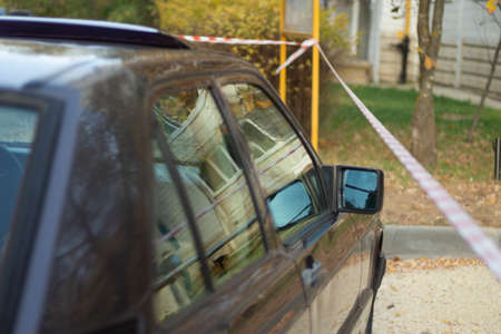 The car is parked at the red tape. Rearview mirror by the car. An old car is parked in the street.の写真素材