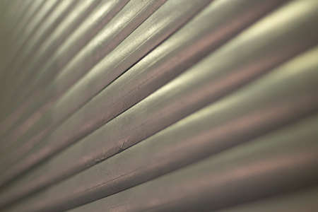 Ribbed texture in evening light. The plastic surface of the blinds. Gray repeating slats shot with open aperture. Simple background.の写真素材