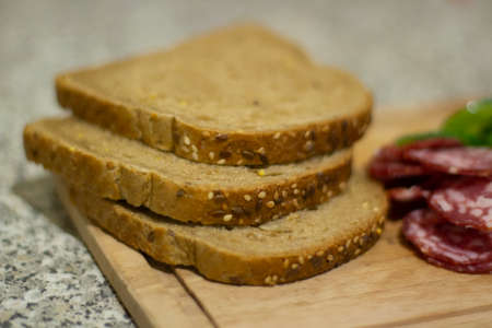 A sausage sandwich. Breakfast with bread and cucumber. Sausage sliced on a board. Simple food made from ingredients.の写真素材