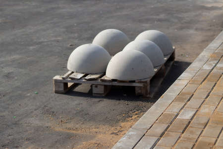 Blocks of movement of cars in the pedestrian zone. The concrete blocks are awaiting installation. Parking restrictor of vehicle passage. Concrete spheres against machines.の写真素材