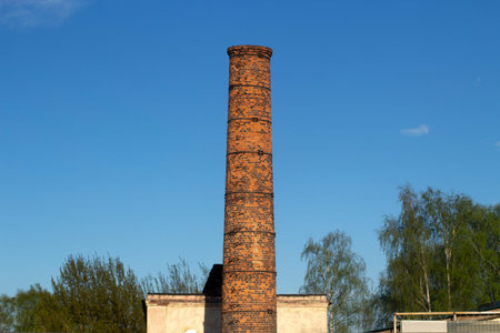 Factory brick pipe. A brick chimney rises against the sky. Old factory in the city.の写真素材