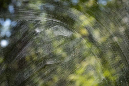 Dirty glass. Washing the window. The transparent glass is covered with dust. Light on a dirty window.の写真素材