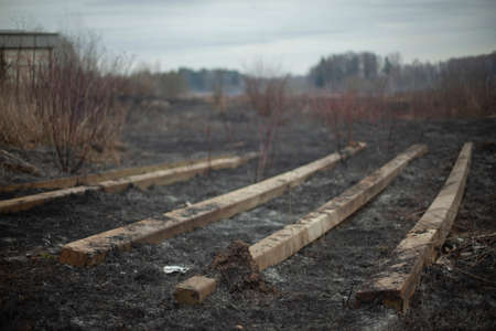 Concrete beams on the ground. Build materials after a fire. Remains on the scorched earth. Concrete blocks.の写真素材