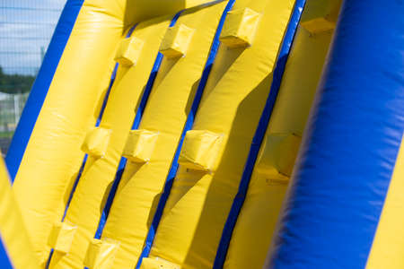 Inflatable obstacle course for fun. Inflatable structure in the park. A place for the joy of children. Playground. Butut is yellow-blue.の写真素材