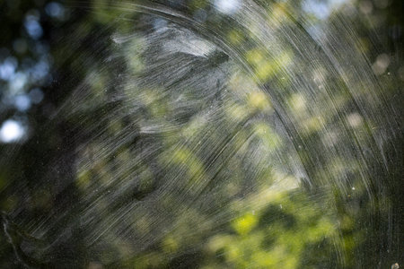 Dirty glass. Washing the window. The transparent glass is covered with dust. Light on a dirty window.の写真素材