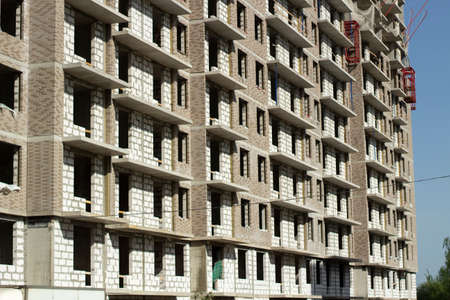 Building a house. Construction site near the house. Construction of a multi-storey building from concrete slabs.の写真素材