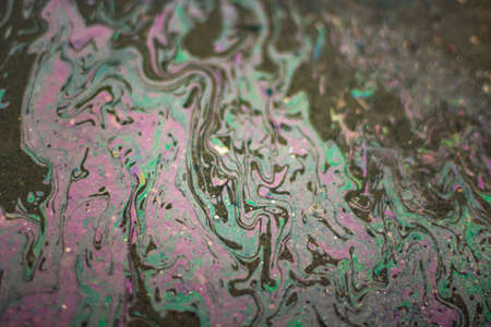 Gasoline on the asphalt. The texture of the fuel spilled on the road. Gasoline shimmers in all colors.の写真素材