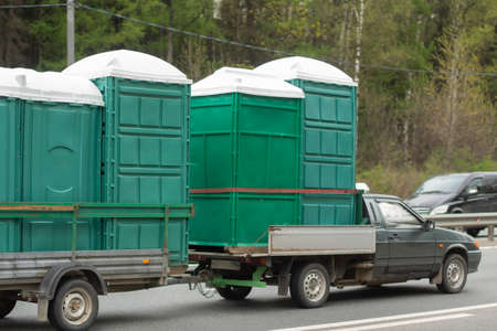 The car carries dry closets on a trailer. Dry closets are transported for repairs. Transportation of bulky objects.の写真素材