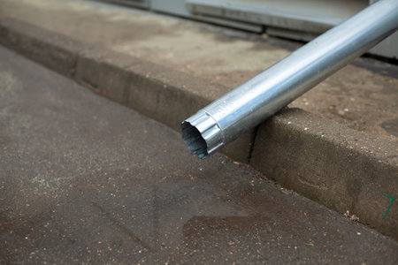 Drainage pipe from the roof of the house. Tin pipe for draining water into a ditch.の写真素材