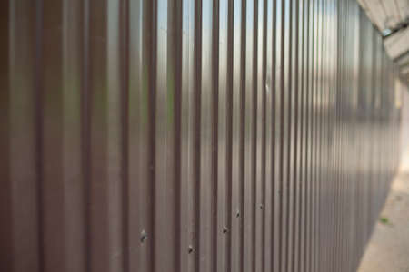 The metal fence is brown. Solid construction site fencing. High stainless steel fence.の写真素材
