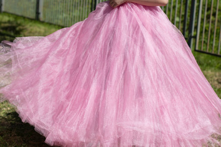 Pink dress. Lush dress in the style of rock and roll. Lightweight fabric at the waist of the girl. Dance skirt on a young girl.の写真素材