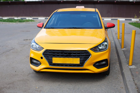 Taxi in the parking lot. A yellow car is parked outside the house. The taxi is thrown near the...