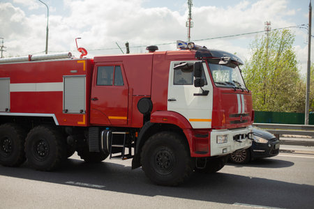 Fire truck on the road. The car goes to extinguish the fire. Rescuers drive along the highway to help.の写真素材