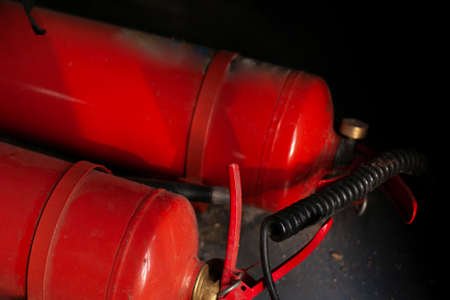 The fire extinguisher is red. A means of protection against fire. Fire extinguisher in a vehicle. Security of the premises.の写真素材