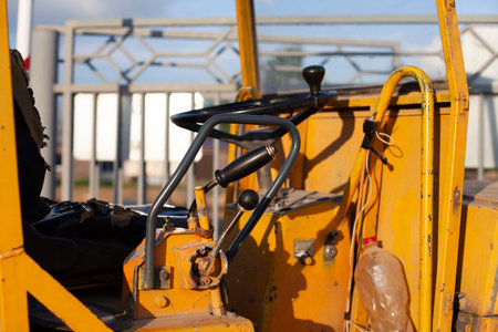 The steering wheel is at the bulldozer. Bulldozer in the parking lot. Old industrial equipment.