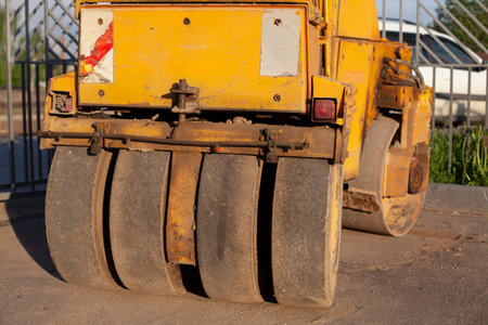Bulldozer for paving yellow asphalt. Heavy machinery for road repair. Working car in the parking lot. The old stacker stands motionless.の写真素材