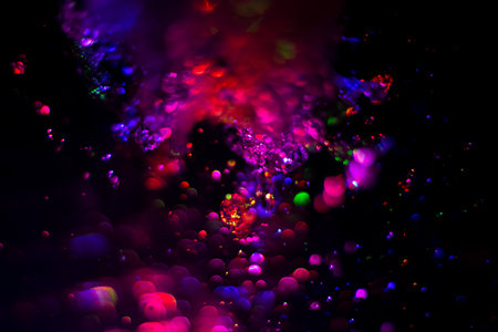 Colored water texture. Splashes of water lit in different colors. Close-up shot of water from the fountain. Bright colors water flow background.の写真素材